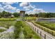 Boardwalk path winds through a lakeside park with birdwatching tower at 1724 Blue Lagoon Cir, Mascotte, FL 34753