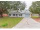 White single story home with a green lawn and driveway at 4 Cedar Trace Way, Ocala, FL 34472