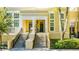 Two-story townhome with a charming porch, double doors, and manicured landscaping at 418 Water St, Kissimmee, FL 34747