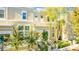 Tan townhome with front porch, landscaping, and tree-lined street at 418 Water St, Kissimmee, FL 34747
