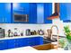 Modern kitchen with blue cabinets, copper range hood, and farmhouse sink at 418 Water St, Kissimmee, FL 34747