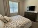 Well-lit bedroom with queen bed, dresser, and window coverings at 7673 Fairfax Dr, Kissimmee, FL 34747