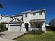 Two-story home with a two-car garage and landscaped lawn at 7673 Fairfax Dr, Kissimmee, FL 34747