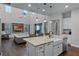Modern kitchen with a large island, white cabinets and open to living room at 8279 Nemours Pkwy, Orlando, FL 32827