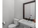 Modern powder room with pedestal sink and dark-framed mirror at 8279 Nemours Pkwy, Orlando, FL 32827