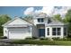 Charming two-story home with a gray tiled roof, blue double door, and attached two-car garage at 932 Tassleflower Trl, Saint Cloud, FL 34771