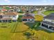 Backyard view of a home with a large lawn and lake access at 1651 Kingfisher Ct, Kissimmee, FL 34746