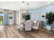 Dining room with light wood table, six chairs and a blue accent wall at 3529 Banana Shrub Blvd, Clermont, FL 34711