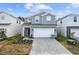 Two-story house with gray siding and a paved driveway at 4428 Kaipo Rd, Davenport, FL 33897