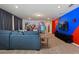 Game room boasts a superhero mural, sectional sofa and TV at 4428 Kaipo Rd, Davenport, FL 33897