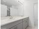 Double vanity bathroom with gray cabinets and a shower at 5286 Tuscany Ln, Davenport, FL 33897
