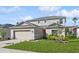 Two-story house with beige siding, a two-car garage, and landscaping at 5286 Tuscany Ln, Davenport, FL 33897