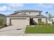 Two-story house with beige siding, a two-car garage, and landscaping at 5286 Tuscany Ln, Davenport, FL 33897