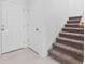 Front entry with white door, storage closet and carpeted staircase at 5286 Tuscany Ln, Davenport, FL 33897