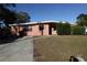 Pink single-story home with a well-maintained lawn and driveway at 6119 Bolling Dr, Orlando, FL 32808