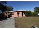 Pink single-story home with a well-maintained lawn and driveway at 6119 Bolling Dr, Orlando, FL 32808