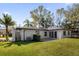 Back of the house, showcasing a patio and landscaping at 8 Pine Ct, Yalaha, FL 34797