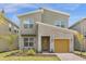 Two-story home with a modern design, stone accents, and a yellow garage door at 8940 Play Through Dr, Davenport, FL 33896
