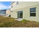 Backyard view of the house showcasing a patio and grassy area at 871 Fillmore Ct, Davenport, FL 33837