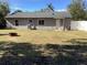 View of the back of the house, backyard with firepit and white fence at 1111 South St, Eustis, FL 32726