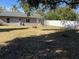 Large backyard with a firepit, surrounded by trees and a white fence at 1111 South St, Eustis, FL 32726