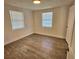 Bright bedroom with wood-look floors and two windows at 1503 33Rd Nw St, Winter Haven, FL 33881