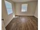 Bright bedroom featuring wood-look floors and two windows at 1503 33Rd Nw St, Winter Haven, FL 33881