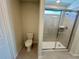 Bathroom featuring a toilet and a shower with glass doors at 16230 Trinidad Way, Clermont, FL 34714