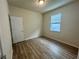 Bright bedroom featuring wood laminate floors and a window at 16230 Trinidad Way, Clermont, FL 34714