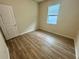 Simple bedroom with wood laminate flooring and a window at 16230 Trinidad Way, Clermont, FL 34714