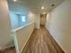 Upstairs hallway with light wood laminate flooring and two doors at 16230 Trinidad Way, Clermont, FL 34714