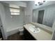 Clean bathroom with white tile, dark vanity, and tub at 2355 Cypress Rd, Deland, FL 32724