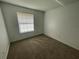 Another bright bedroom with carpeted floor and a window at 2355 Cypress Rd, Deland, FL 32724