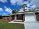 Brick house with a white garage door and landscaping at 2355 Cypress Rd, Deland, FL 32724