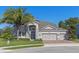 Two-story house with stone accents, three-car garage, and manicured lawn at 32004 Redtail Reserve Blvd, Sorrento, FL 32776