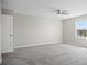 Bright bedroom with gray carpet, ceiling fan, and large window at 3207 Stratton Cir, Kissimmee, FL 34744