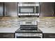 Modern kitchen features stainless steel appliances and tile backsplash at 3207 Stratton Cir, Kissimmee, FL 34744