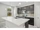 Modern kitchen with dark cabinetry, quartz countertops, and stainless steel appliances at 3207 Stratton Cir, Kissimmee, FL 34744