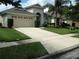 Tan one-story house with a two-car garage and manicured landscaping at 347 Streamview Way, Winter Springs, FL 32708