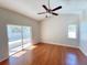 Bright bedroom with wood floors, ceiling fan, and sliding glass door to patio at 4134 Tunitas Ct, Orlando, FL 32817