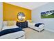 Twin bedroom with mustard yellow accent wall and matching decor at 7457 Marker Ave, Kissimmee, FL 34747