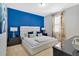 Spacious bedroom with a white platform bed and blue accent wall at 7457 Marker Ave, Kissimmee, FL 34747