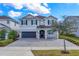 Two-story house with gray siding, dark gray garage doors, and a paved driveway at 7457 Marker Ave, Kissimmee, FL 34747