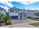 Two-story house with gray siding, dark gray garage doors, and a paved driveway at 7457 Marker Ave, Kissimmee, FL 34747