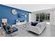 Living room with white sectional sofa, blue accent wall, and access to backyard patio at 7457 Marker Ave, Kissimmee, FL 34747