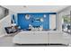 Open concept living room with white sectional sofa and blue accent wall at 7457 Marker Ave, Kissimmee, FL 34747