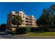 Three-story condo building with palm trees and lush landscaping at 7500 Toscana Blvd # 341, Orlando, FL 32819