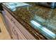 Close-up of a granite kitchen counter with light-colored cabinets at 7500 Toscana Blvd # 341, Orlando, FL 32819