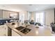 Modern kitchen island with double sink, open to living area at 8943 Cabot Cliffs Dr, Davenport, FL 33896