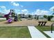 playground with slides, swings, and a bench at 8943 Cabot Cliffs Dr, Davenport, FL 33896